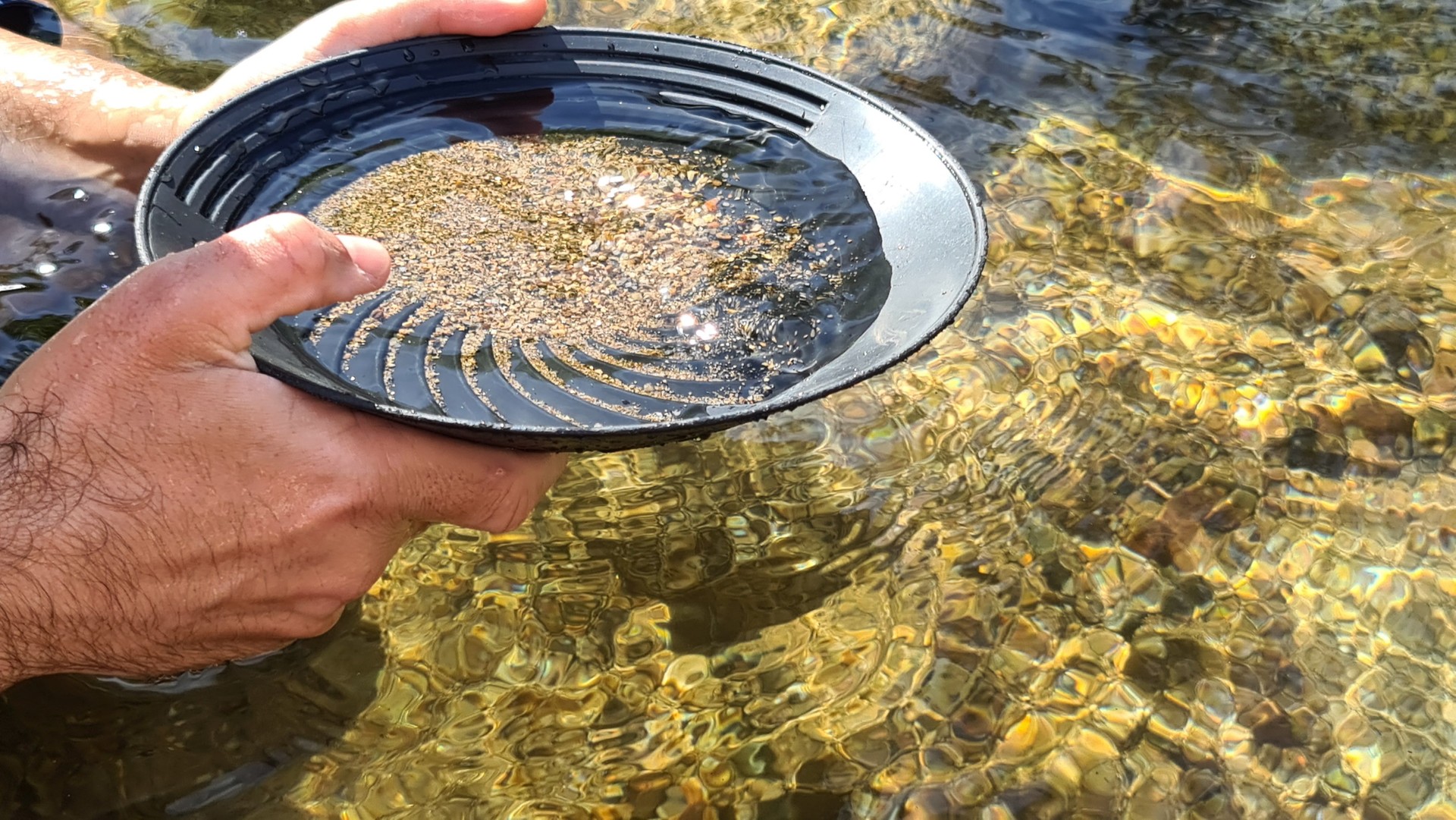 Close-up of a man's hands holding a gold panning prospecting pan